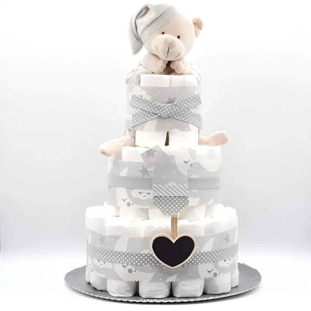 Tarta de pañales de tres pisos en gris y blanco con osito de peluche con gorro, lazos de estrellas y pizarrita de corazón