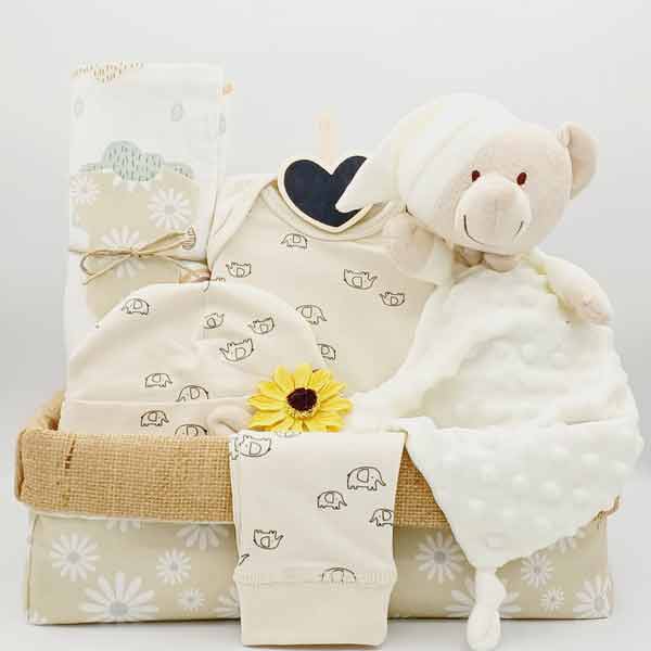 Canastilla de bebé Margaritas con doudou de osito, ropa beige, girasol y cesta de yute con margaritas