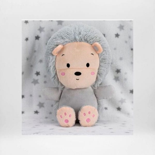 Peluche de erizo gris y rosa para bebé sobre fondo de estrellas